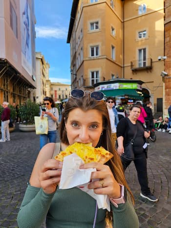 Rapariga a comer pizza da Pizzaria Trilussa, em Roma