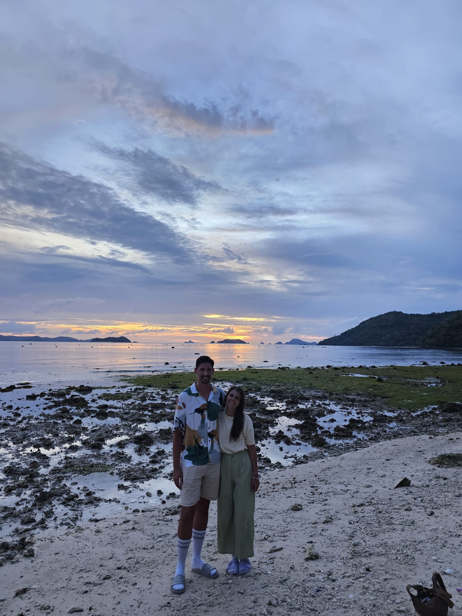 mosquitos-nas-filipinas-roupa-larga Casal na praia, ao pôr do sol, com roupas largas para se protegerem dos mosquitos nas Filipinas