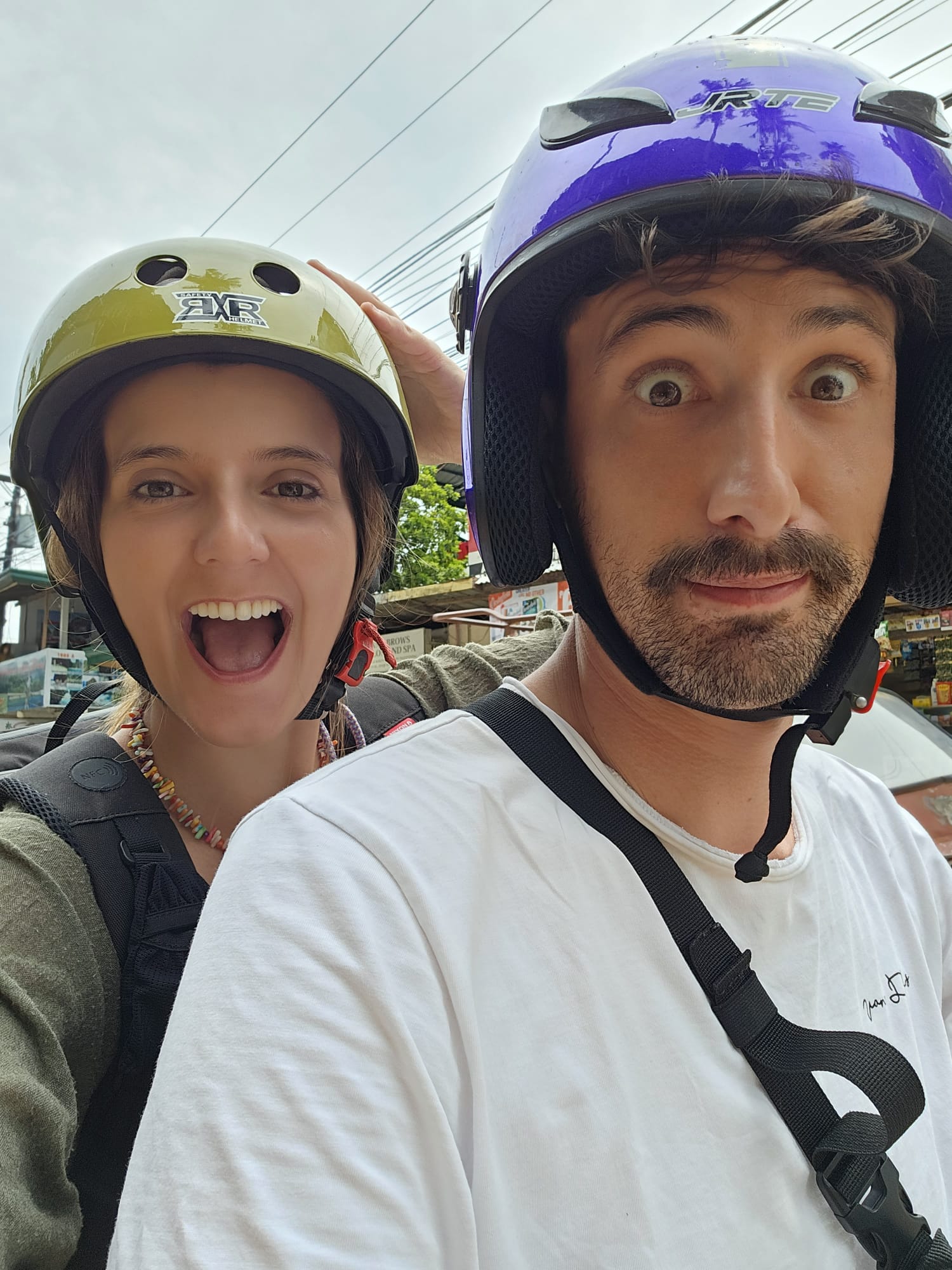 Casal feliz a conduzir uma mota em El Nido