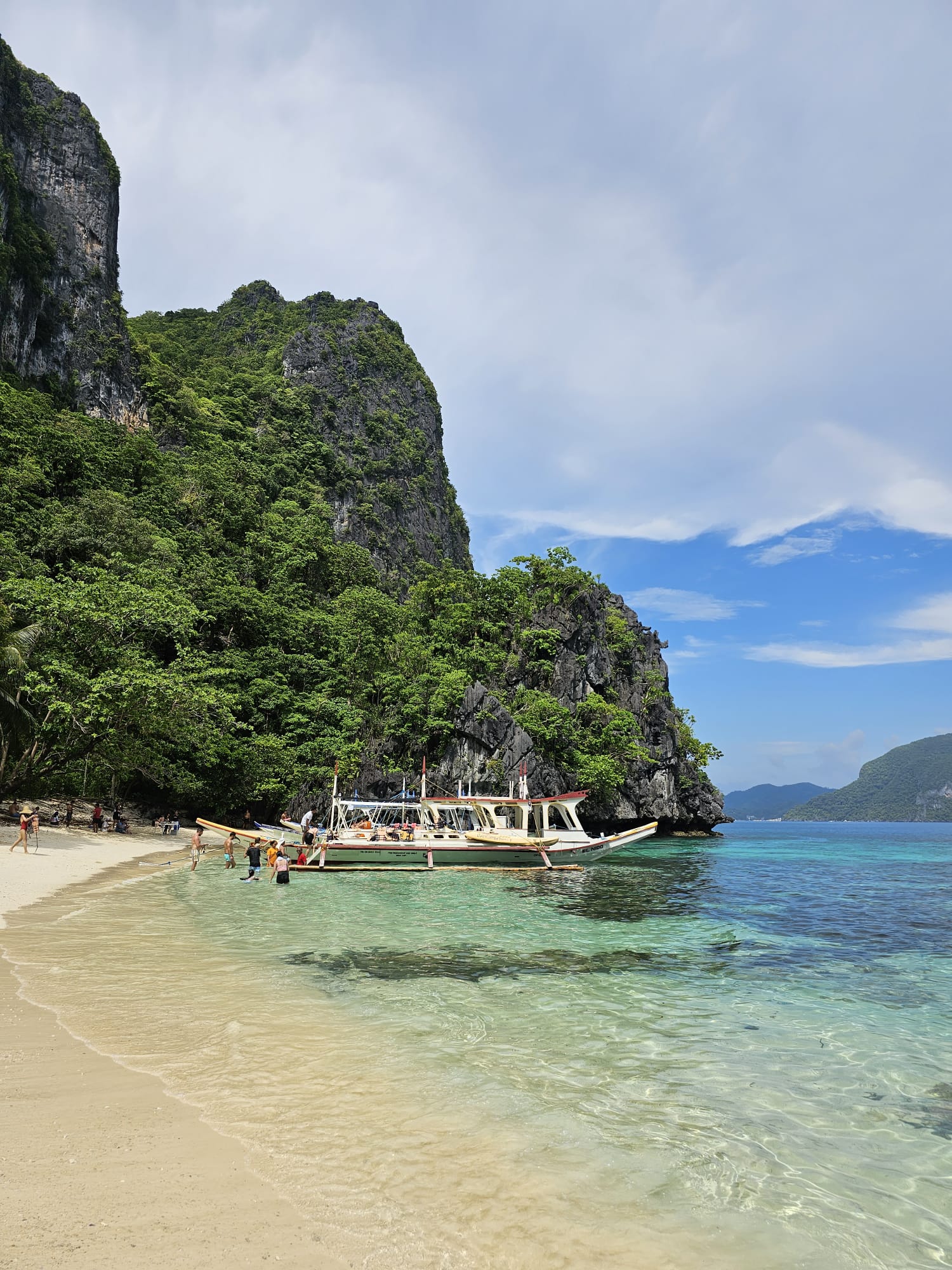 Paisagem de uma praia paradisíaca das Filipinas, com um barco ao fundo